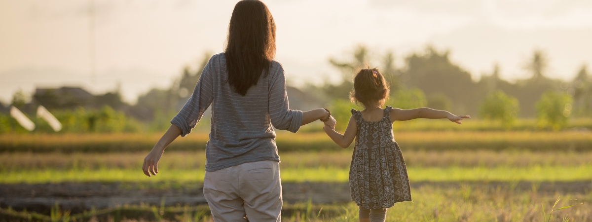 Mom and child holding hands outside